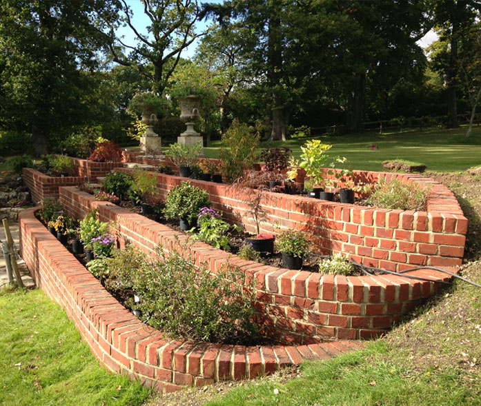 Raised brick bed landscaping with central steps and planting.