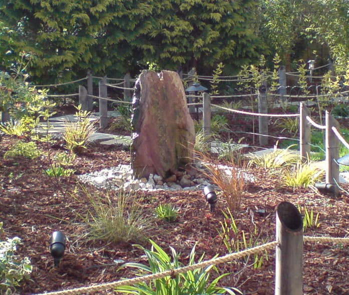 Drilled slate rock with spout in top circulating through reservoir beneath.