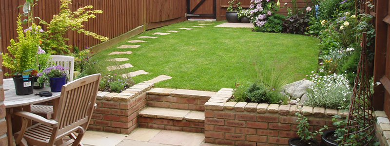 Raised grass area with tiled patio in Poole